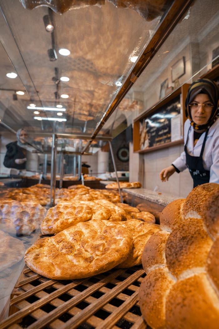 services-04 A bakery showcasing freshly baked bread with a staff member in view. Warm, inviting ambiance.